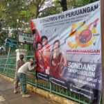 Empat aparat personel Satpol PP Kelurahan Susukan, Kecamatan Ciracas, Jakarta Timur, menurunkan spanduk partai di sepanjang Jalan Raya Bogor, Rabu (1/3). Foto: Joesvicar Iqbal/ipol.id