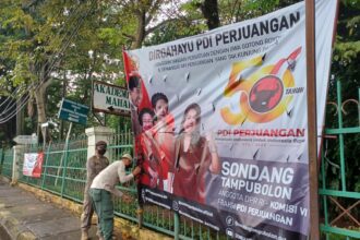 Empat aparat personel Satpol PP Kelurahan Susukan, Kecamatan Ciracas, Jakarta Timur, menurunkan spanduk partai di sepanjang Jalan Raya Bogor, Rabu (1/3). Foto: Joesvicar Iqbal/ipol.id