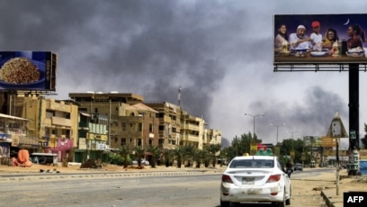 Asap mengepul di sepanjang jalan sepi di Khartoum pada 16 April 2023, saat berkecamuknya pertempuran antara kekuatan 2 jenderal yang bersaing. (Foto: AFP)