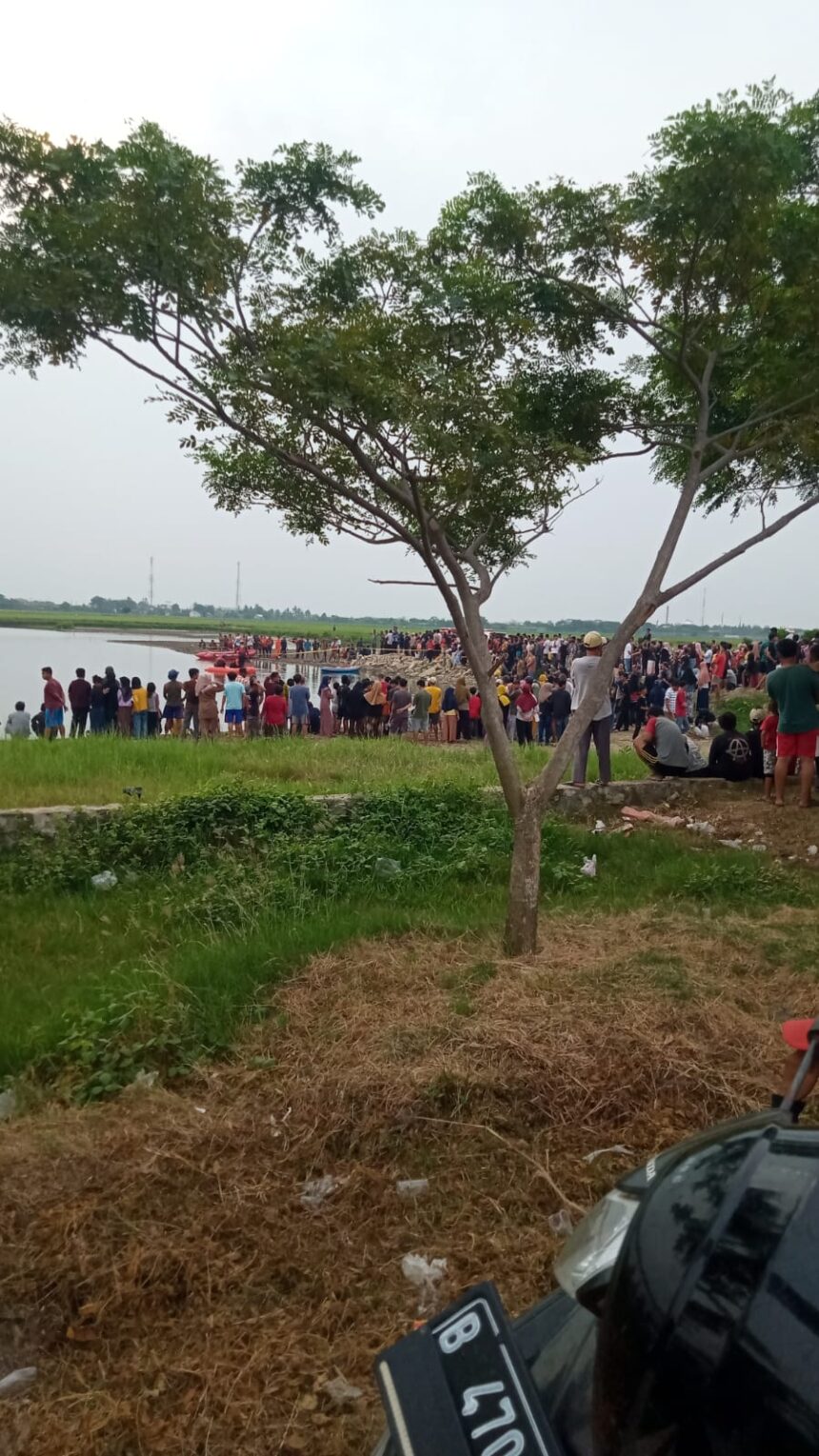 Warga memadati lokasi penemuan jasad kedua bocah yang tenggelam di Danau Perumahan Cluster Majapahit Panjibuwono, Kecamatan Babelan, Kabupaten Bekasi, Kamis (18/5). Foto: Grup WA warga Babelan.