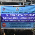 Spanduk pemberitahuan penutupan Jalan Swadaya, Kelurahan Pondok Ranggon, Kecamatan Cipayung, Jakarta Timur dilakukan mulai tanggal 29 Juli hingga 15 Desember 2023, Senin (31/7). Foto: Joesvicar Iqbal/ipol.id
