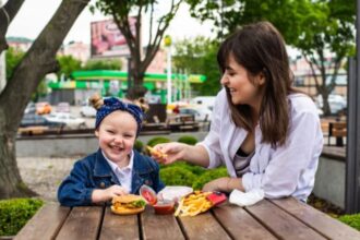 Ilustrasi - Seorang Ibu memberikan makanan kentang goreng kepada buah hatinya. Foto: Freepik