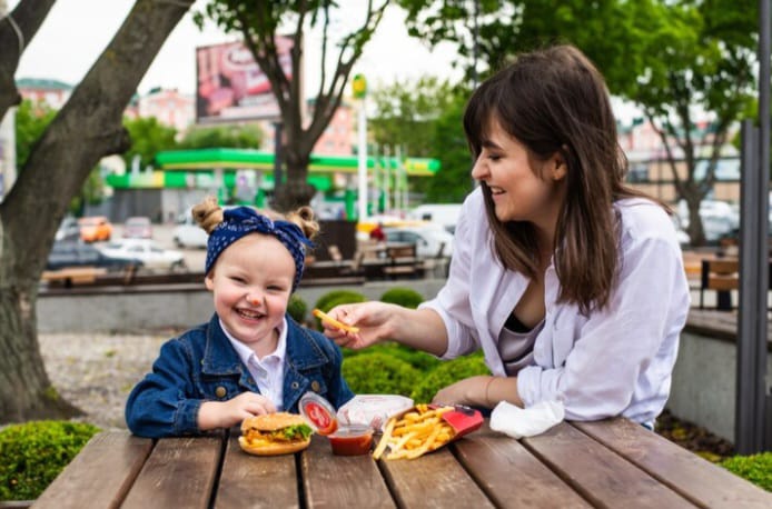 Ilustrasi - Seorang Ibu memberikan makanan kentang goreng kepada buah hatinya. Foto: Freepik