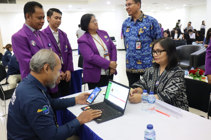 Wakil Rektor UKI, Ied Veda Rimrosa Sitepu,, saat mencoba layanan dari Dinas Dukcapil terkait IKD dalam rangka Dies Natalis ke-70 UKI.