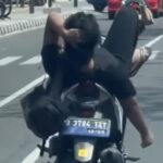 Dalam video yang menyebar di media sosial, pemotor Vario dengan merebahkan badannya ke jok belakang dan kakinya berada di setang kemudi. Foto: NTMC