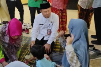 Kepala Bagian Kesejahteraan Rakyat Kota Administrasi Jakarta Timur, Rohmad ikut melakukan Pemberian Makanan Tambahan (PMT) kepada 13 anak terindikasi stunting di Gedung Serbaguna RW 03 Kelurahan Munjul, Kecamatan Cipayung Jakarta Timur, Jumat (13/10). Foto: Ist