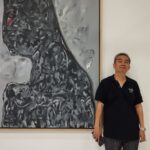 Tjahjadi Hartono dan salah satu lukisan abstraknya. Foto: Ist