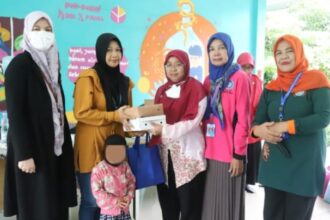 Sekretaris Kelurahan Jagakarsa, Zubaidah saat menyerahkan bantuan paket Pemberian Makanan Tambahan (PMT) kepada para Ibu dari balita terduga stunting di Ruang Publik Terpadu Ramah Anak (RPTRA) Beringin, Jagakarsa, Jakarta Selatan, Jumat (1/12).
