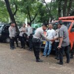 Puluhan aparat kepolisian dari Polres Metro Jakarta Timur dan Polsek Kramat Jati melakukan penjagaan di lahan parkir di pasar sayur mayur terbesar di Pasar Induk Kramat Jati, Rabu (6/12). Foto: Ist
