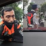 Petugas Dishub berada diatas kap mobil setelah cekcok dengan taksi online. Foto: IG, @terang_media (tangkap layar)