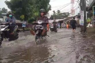 Sejumlah pemotor nekat menerobos genangan di Jalan Raya Jambore, Cibubur, Ciracas, Jakarta Timur, Rabu (10/1) siang. Foto: Joesvicar Iqbal/ipol.id