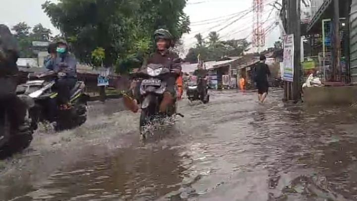 Sejumlah pemotor nekat menerobos genangan di Jalan Raya Jambore, Cibubur, Ciracas, Jakarta Timur, Rabu (10/1) siang. Foto: Joesvicar Iqbal/ipol.id