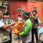 Deputi Bidang Penanganan Darurat Badan Nasional Penanggulangan Bencana (BNPB) Mayjen TNI Fajar Setyawan (baju putih dengan rompi) secara simbolis memberi bantuan penanganan bencana puting beliung kepada warga masyarakat terdampak di Kecamatan Rancaekek, Kabupaten Bandung, Jawa Barat, Jumat (23/2). Foto: BNPB