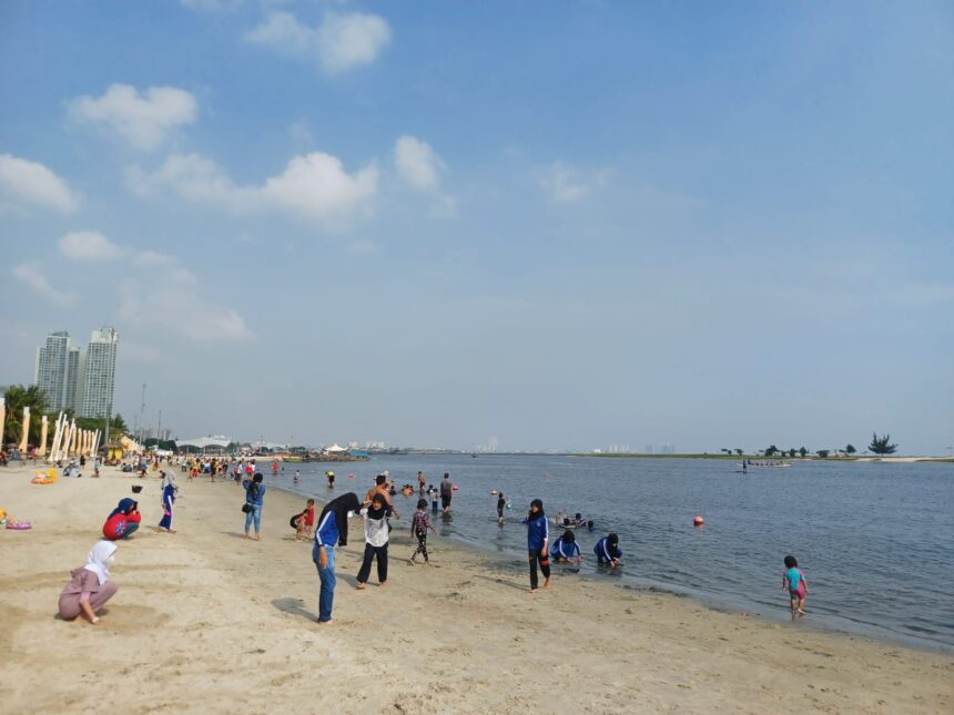 Suasana sejumlah pengunjung bermain pasir di tepi pantai Ancol Taman Impian. Foto: Joesvicar Iqbal/Dok/ipol.id