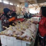 Pedagang ayam potong, Rohmah, 49, ketika melayani seorang pembeli di losnya di Pasar Ciracas, Kelurahan/Kecamatan Ciracas, Jakarta Timur, Rabu (13/3) siang. Foto: Joesvicar Iqbal/ipol.id