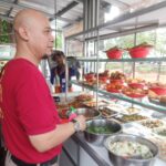 Ketua Komunitas Warung Tegal Nusantara (Kowantara) DKI Jakarta, Izzudin Zidan ketika melayani pembeli. Foto: Joesvicar Iqbal/ipol.id